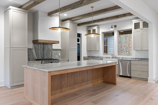 kitchen featuring light hardwood / wood-style flooring, light stone countertops, beam ceiling, a kitchen island, and stainless steel appliances