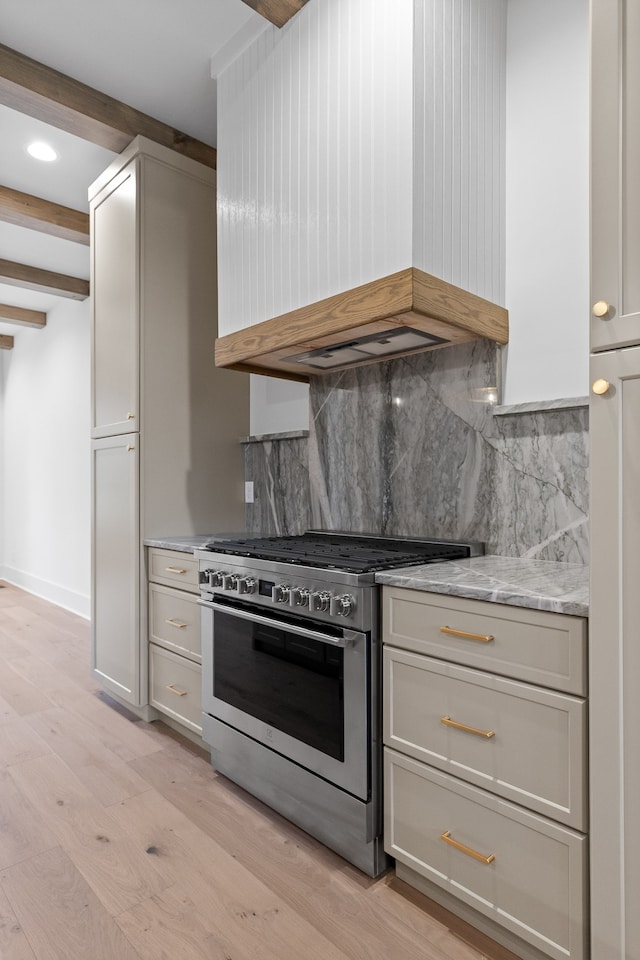 kitchen featuring light stone counters, custom range hood, light hardwood / wood-style flooring, beamed ceiling, and stainless steel range with gas stovetop