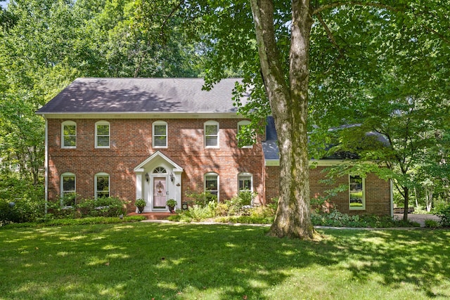 colonial home featuring a front lawn