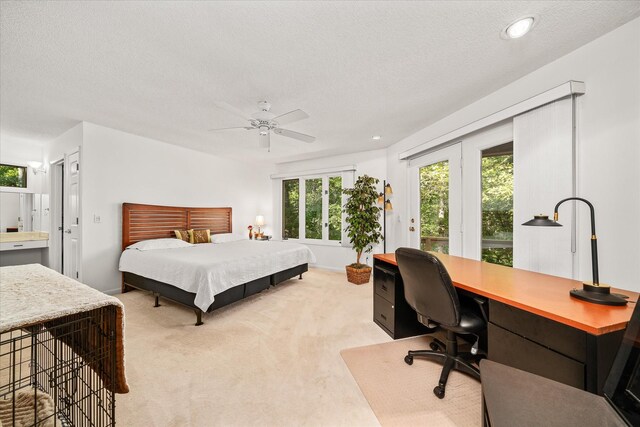 carpeted bedroom featuring a textured ceiling, ceiling fan, and multiple windows