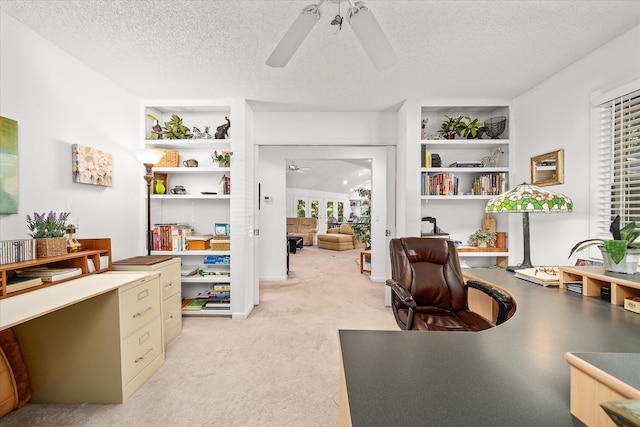 office featuring built in features, ceiling fan, light carpet, and a textured ceiling