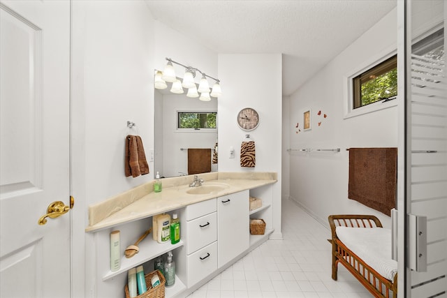 bathroom with a textured ceiling, vanity, and tile patterned flooring