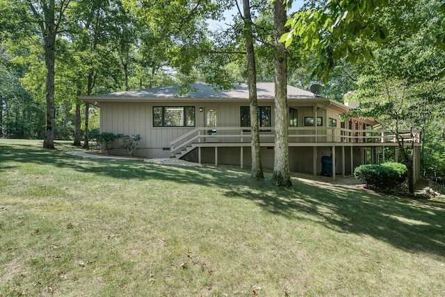 rear view of house featuring a lawn and a deck