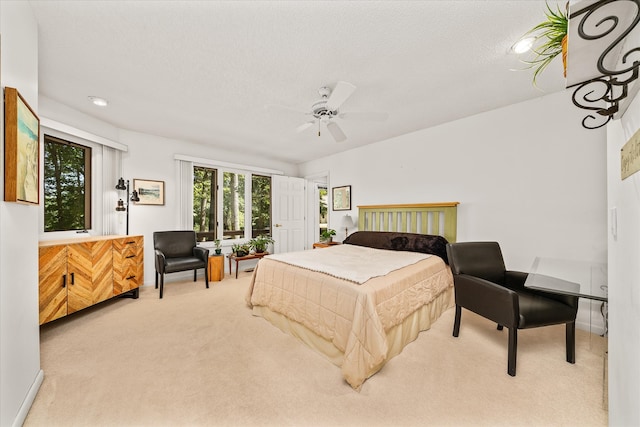 carpeted bedroom featuring a textured ceiling and ceiling fan