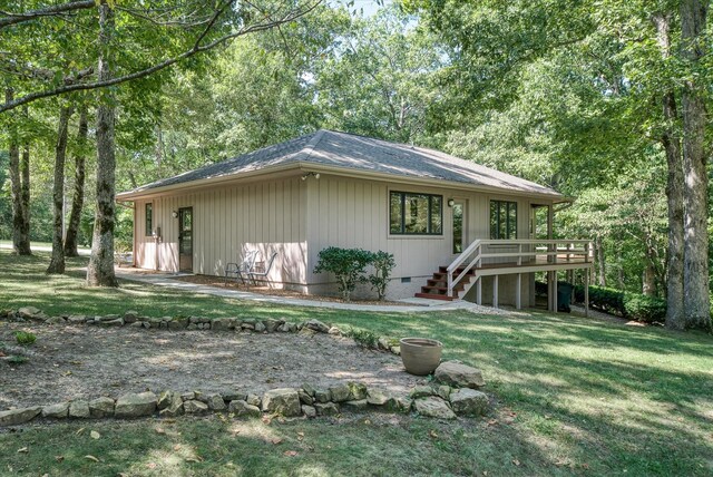 view of side of property with a yard and a deck