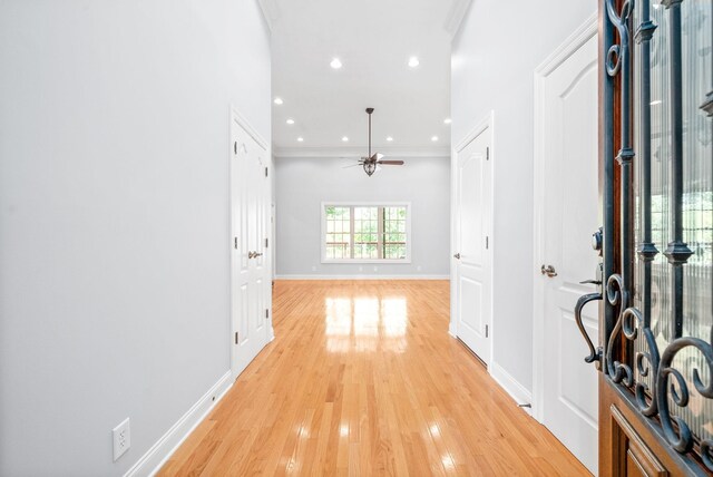 interior space with crown molding, ceiling fan, and light hardwood / wood-style floors