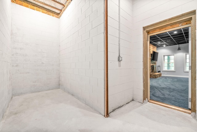 bathroom featuring a brick fireplace and concrete floors