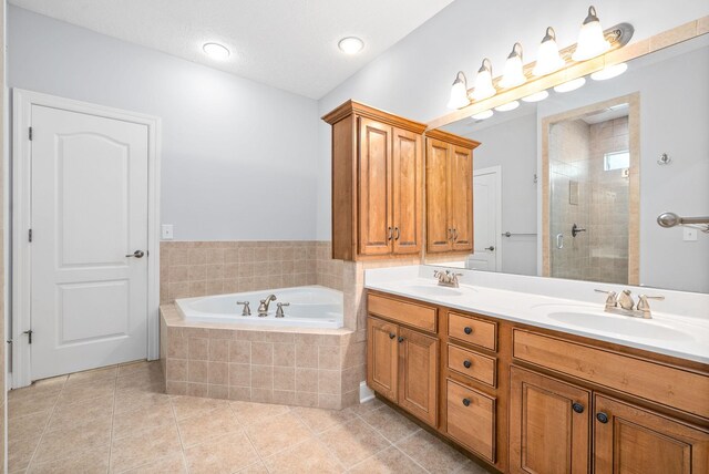 bathroom featuring tile patterned flooring, vanity, and plus walk in shower