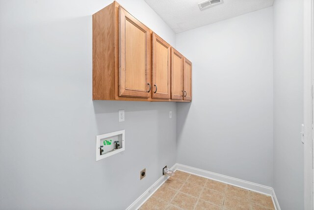 clothes washing area with hookup for a washing machine, cabinets, electric dryer hookup, and a textured ceiling