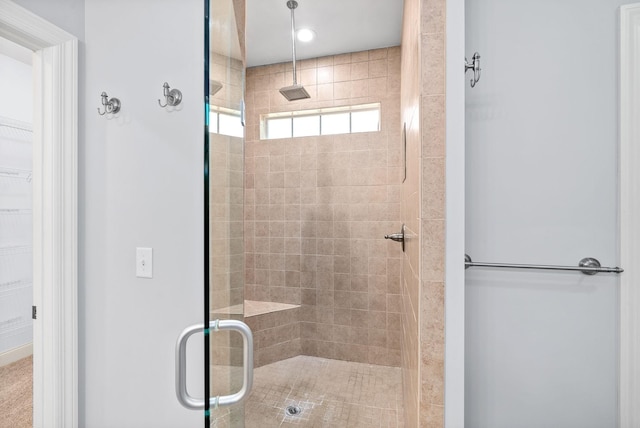 bathroom featuring a stall shower and a walk in closet