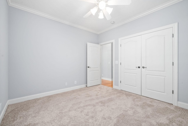 unfurnished bedroom with baseboards, a closet, carpet flooring, and crown molding