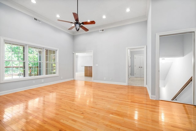 interior space featuring a towering ceiling, visible vents, and crown molding