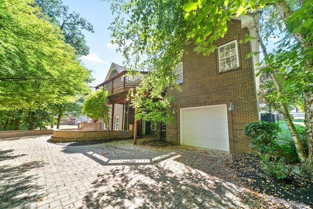 view of home's exterior with a garage and a balcony