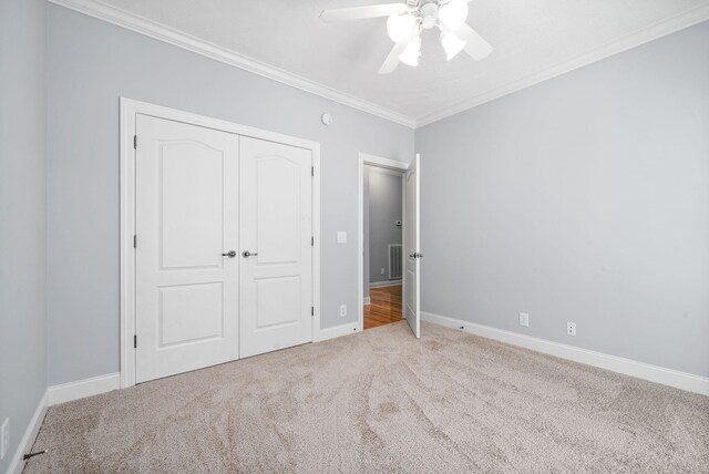 unfurnished bedroom with ornamental molding, ceiling fan, and carpet floors