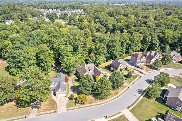 drone / aerial view featuring a residential view and a view of trees