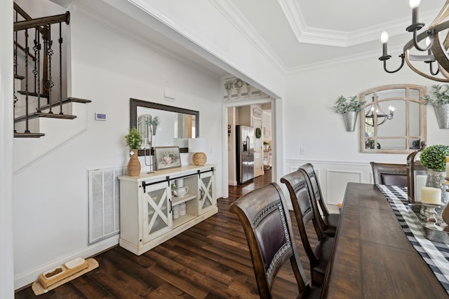 dining room with dark hardwood / wood-style flooring, a notable chandelier, and ornamental molding