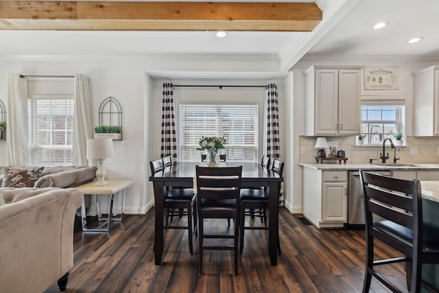 dining space with dark hardwood / wood-style floors, beam ceiling, ornamental molding, and sink