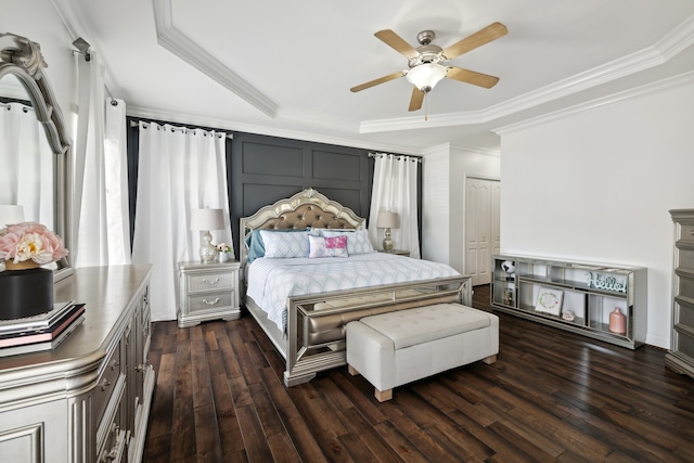 bedroom with crown molding, dark wood-type flooring, ceiling fan, and a closet