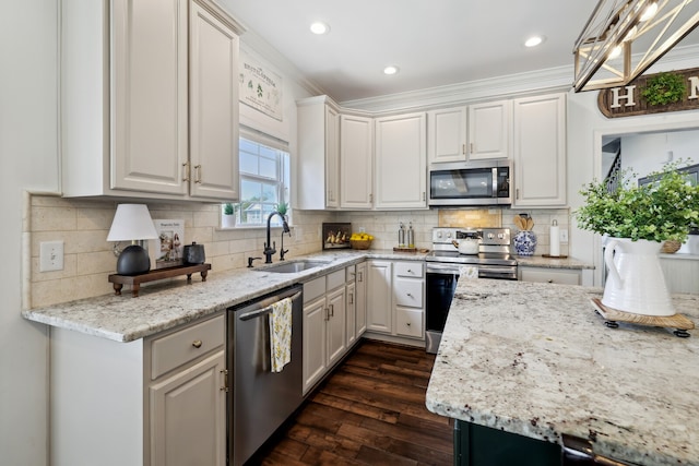 kitchen with appliances with stainless steel finishes, dark wood-type flooring, ornamental molding, sink, and decorative backsplash