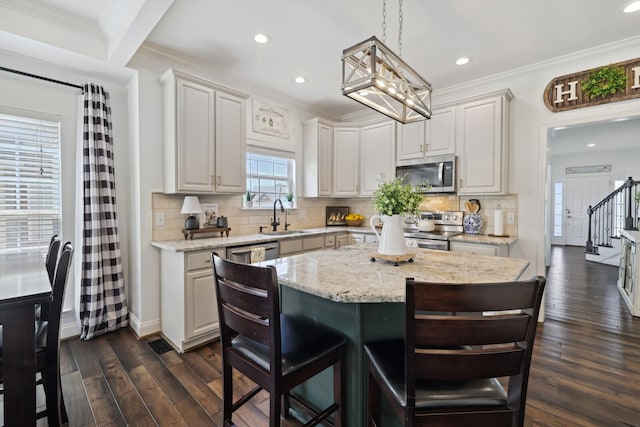 kitchen featuring a chandelier, stainless steel appliances, a center island, light stone countertops, and dark hardwood / wood-style floors