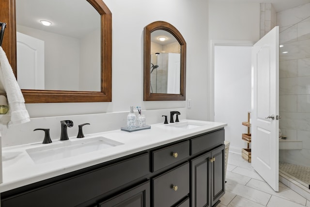 bathroom with vanity and a tile shower