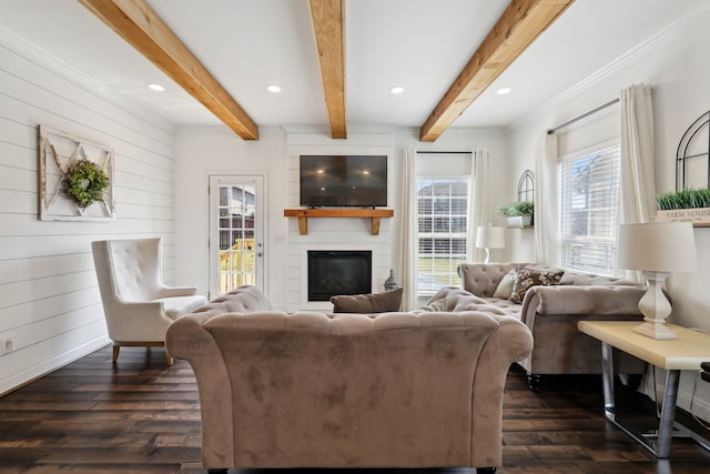 living room with wood walls, beamed ceiling, a fireplace, crown molding, and dark wood-type flooring