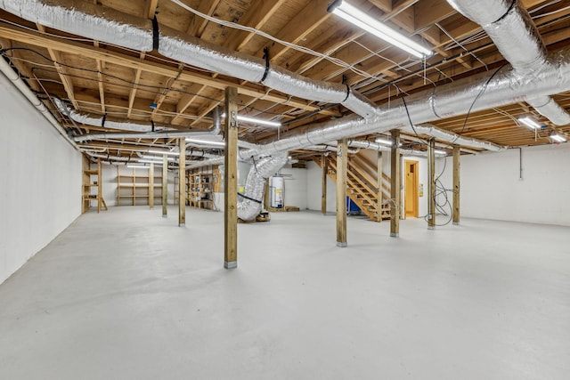 unfinished below grade area featuring water heater and stairs