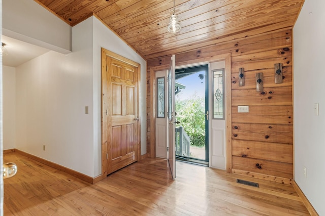 foyer with lofted ceiling, visible vents, light wood-type flooring, wooden ceiling, and baseboards