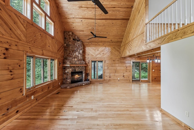 unfurnished living room featuring a ceiling fan, wooden ceiling, and wooden walls