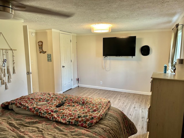 bedroom featuring a textured ceiling, wood finished floors, a ceiling fan, and baseboards