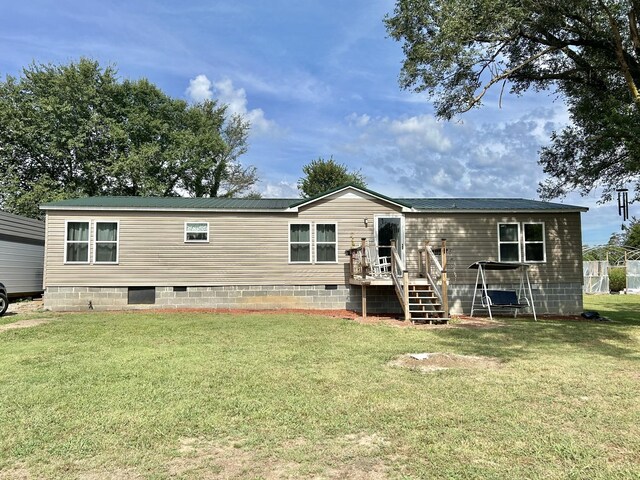 rear view of property with a yard and a wooden deck