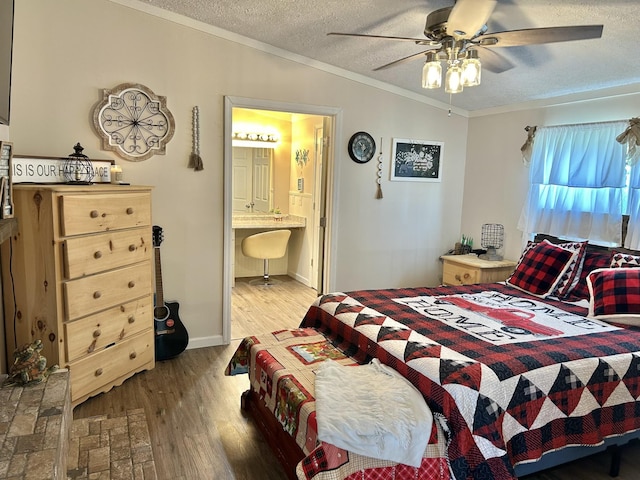 bedroom with a ceiling fan, ensuite bath, ornamental molding, wood finished floors, and a textured ceiling