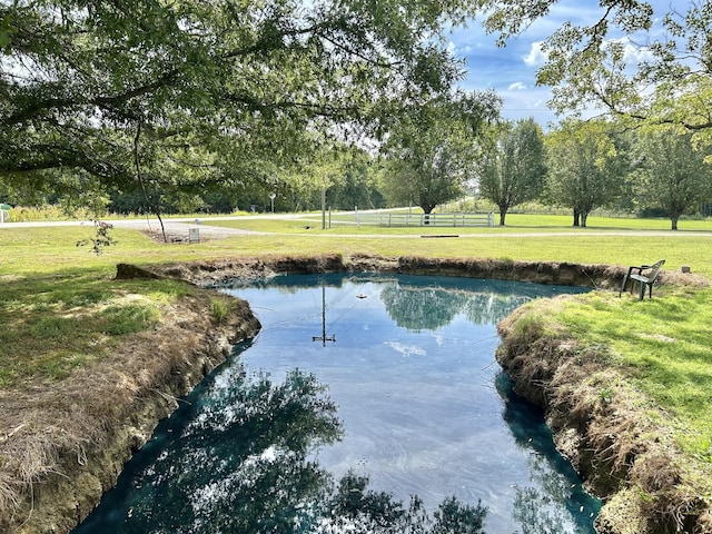 surrounding community featuring a water view and a lawn