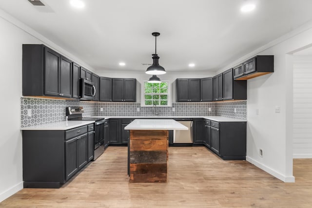 kitchen featuring a kitchen island, light hardwood / wood-style flooring, stainless steel appliances, decorative backsplash, and decorative light fixtures