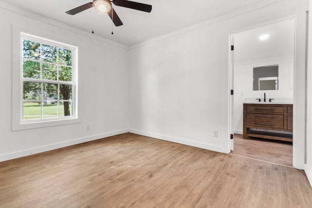 spare room featuring crown molding, light hardwood / wood-style floors, sink, and ceiling fan