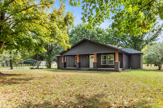 rear view of property with a lawn, central AC unit, and a carport