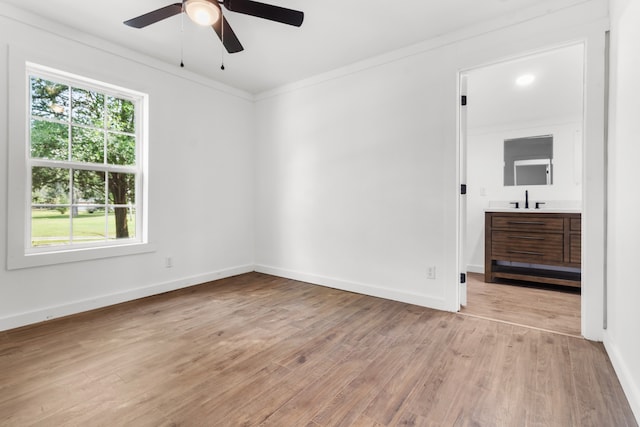 spare room with ceiling fan, sink, crown molding, and light hardwood / wood-style floors