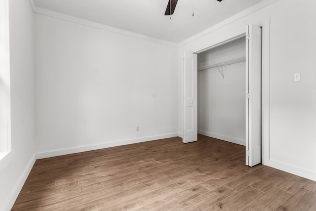 unfurnished bedroom featuring ceiling fan, ornamental molding, light wood-type flooring, and a closet