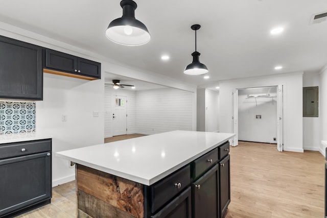 kitchen with light hardwood / wood-style floors, a center island, pendant lighting, and ceiling fan