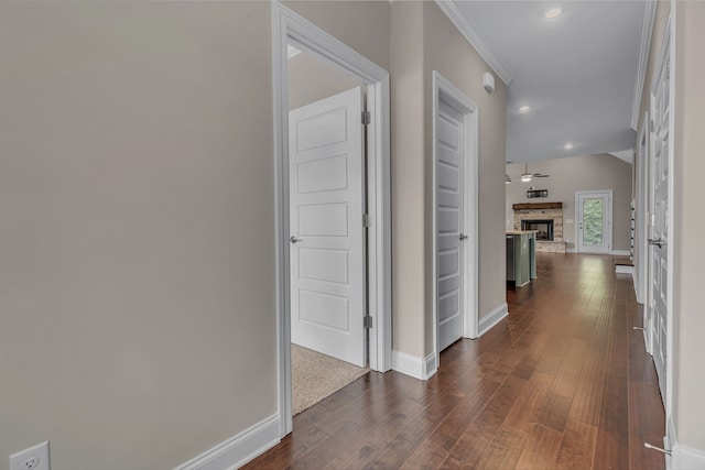 corridor with crown molding and dark wood-type flooring