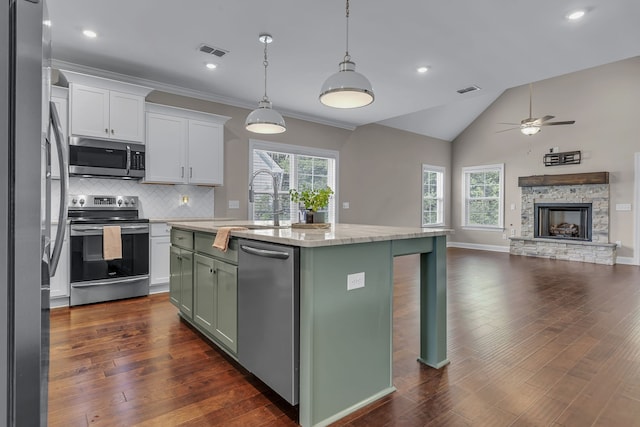 kitchen featuring sink, a center island, dark wood-type flooring, appliances with stainless steel finishes, and lofted ceiling