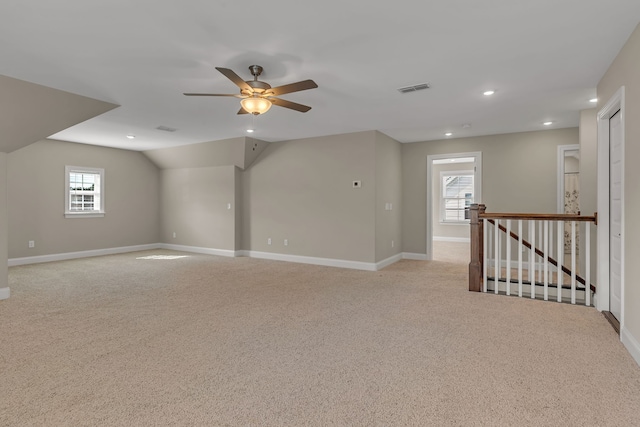 carpeted empty room featuring lofted ceiling, plenty of natural light, and ceiling fan