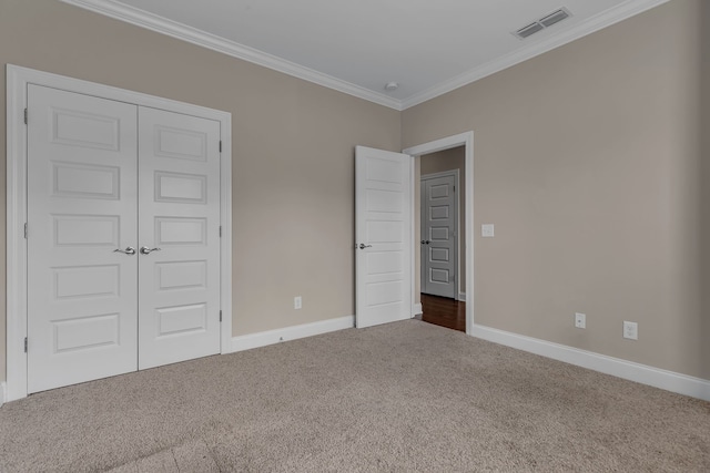 unfurnished bedroom featuring carpet, ornamental molding, and a closet