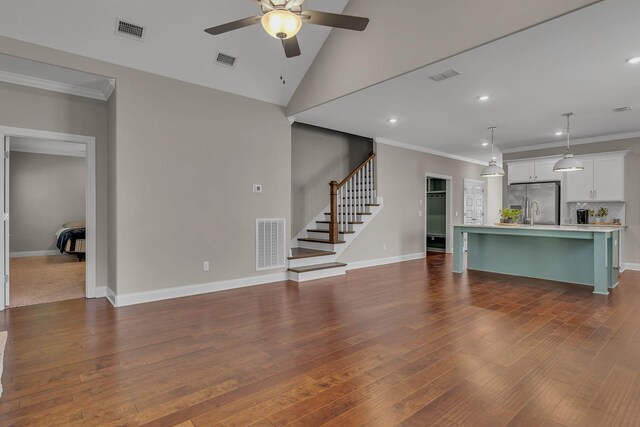 unfurnished living room featuring ceiling fan, ornamental molding, and hardwood / wood-style flooring