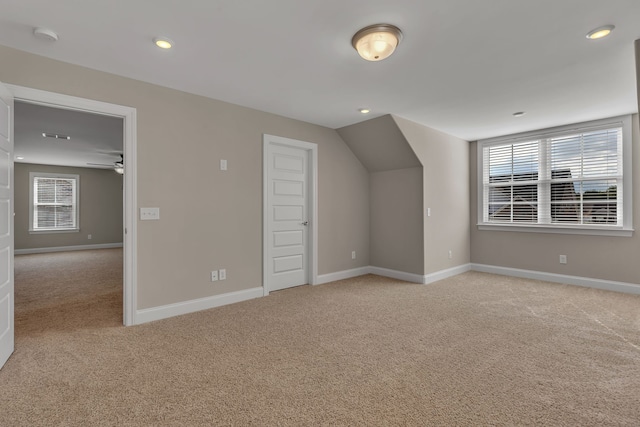 additional living space featuring ceiling fan and light carpet