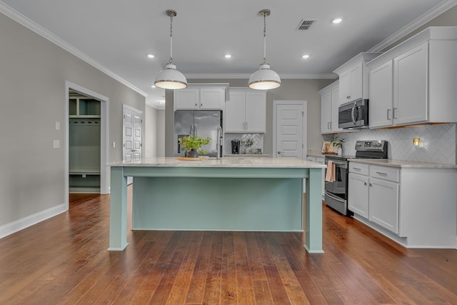 kitchen featuring dark hardwood / wood-style floors, decorative light fixtures, backsplash, appliances with stainless steel finishes, and a kitchen island with sink