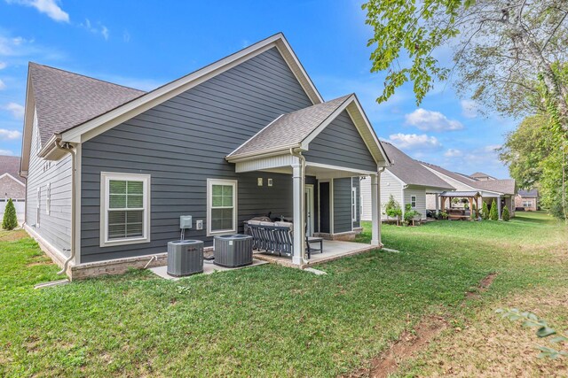 rear view of house featuring cooling unit, a lawn, a patio, and a gazebo