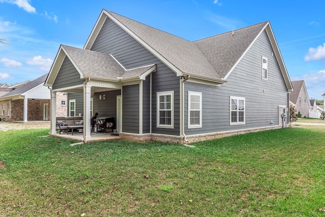 back of property featuring a patio area and a lawn