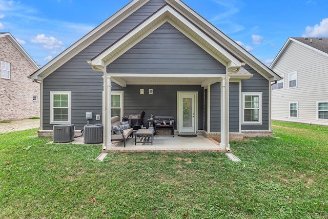 back of house featuring outdoor lounge area, a lawn, a patio area, and central AC