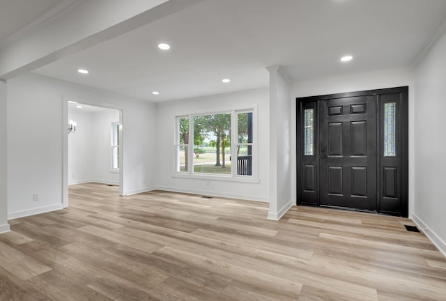 entryway with light wood-type flooring and ornamental molding